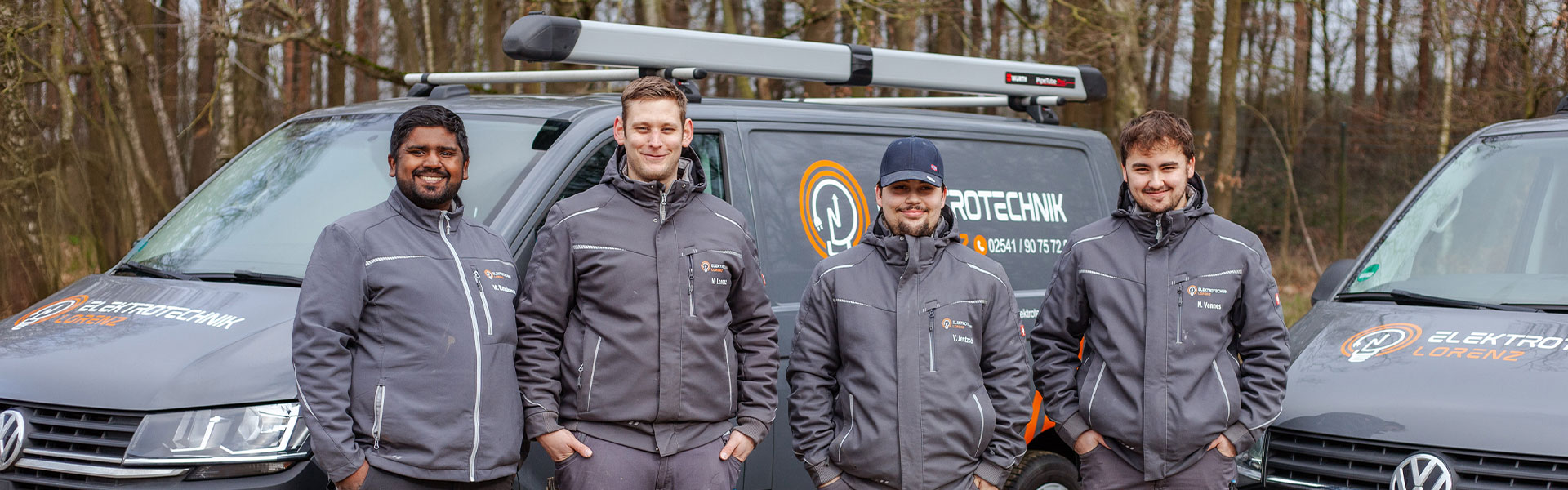 Elektriker in Coesfeld – Karriere im Elektro-Meisterbetrieb im Münsterland Vier Elektriker von Elektrotechnik Lorenz in Coesfeld stehen in Arbeitskleidung vor den Firmenfahrzeugen im Münsterland