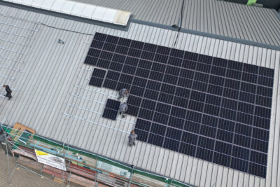 Elektriker im Münsterland – Photovoltaikanlage auf Gewerbedach Luftaufnahme einer großflächigen Photovoltaikanlage auf einem Gewerbedach im Münsterland