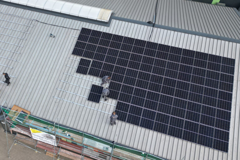 Elektriker im Münsterland – Photovoltaikanlage auf Gewerbedach Luftaufnahme einer großflächigen Photovoltaikanlage auf einem Gewerbedach im Münsterland